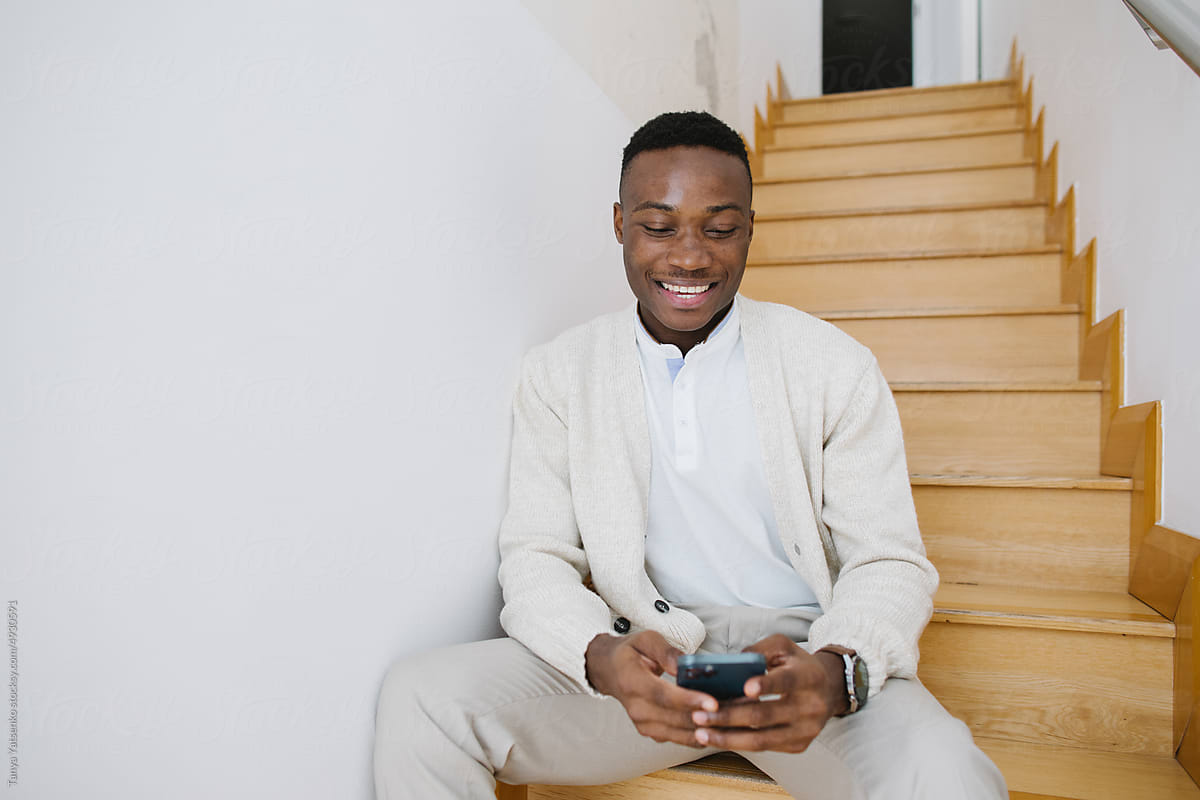 An African man with a mobile phone at the staircase