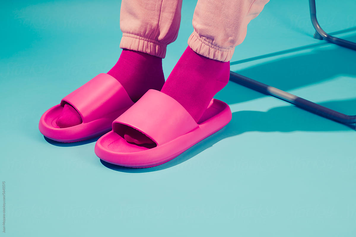 man wearing pink socks and sandals sitting in a folding chair