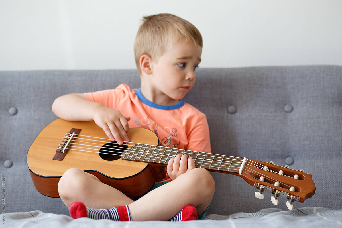 Boy pretending to play a small guitar