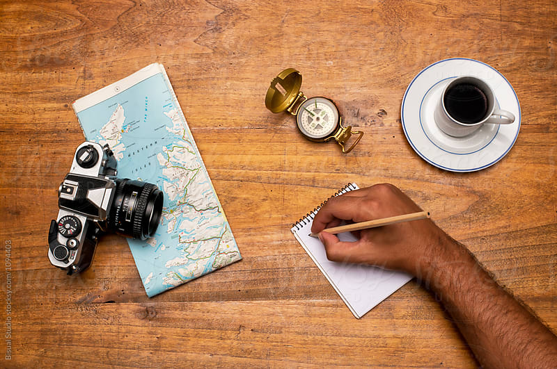 Man planning a tripView of a world map, white paper, coffee and a vintage camera