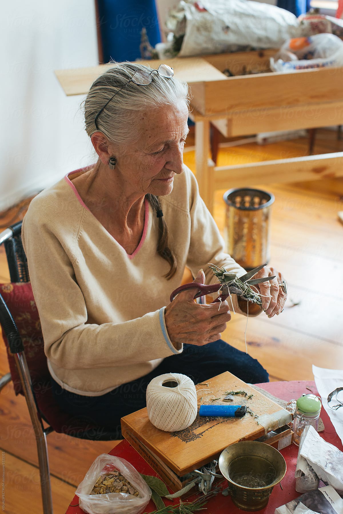 Environmental Portrait of Senior Woman with Grey Hair Making Smudge Stick