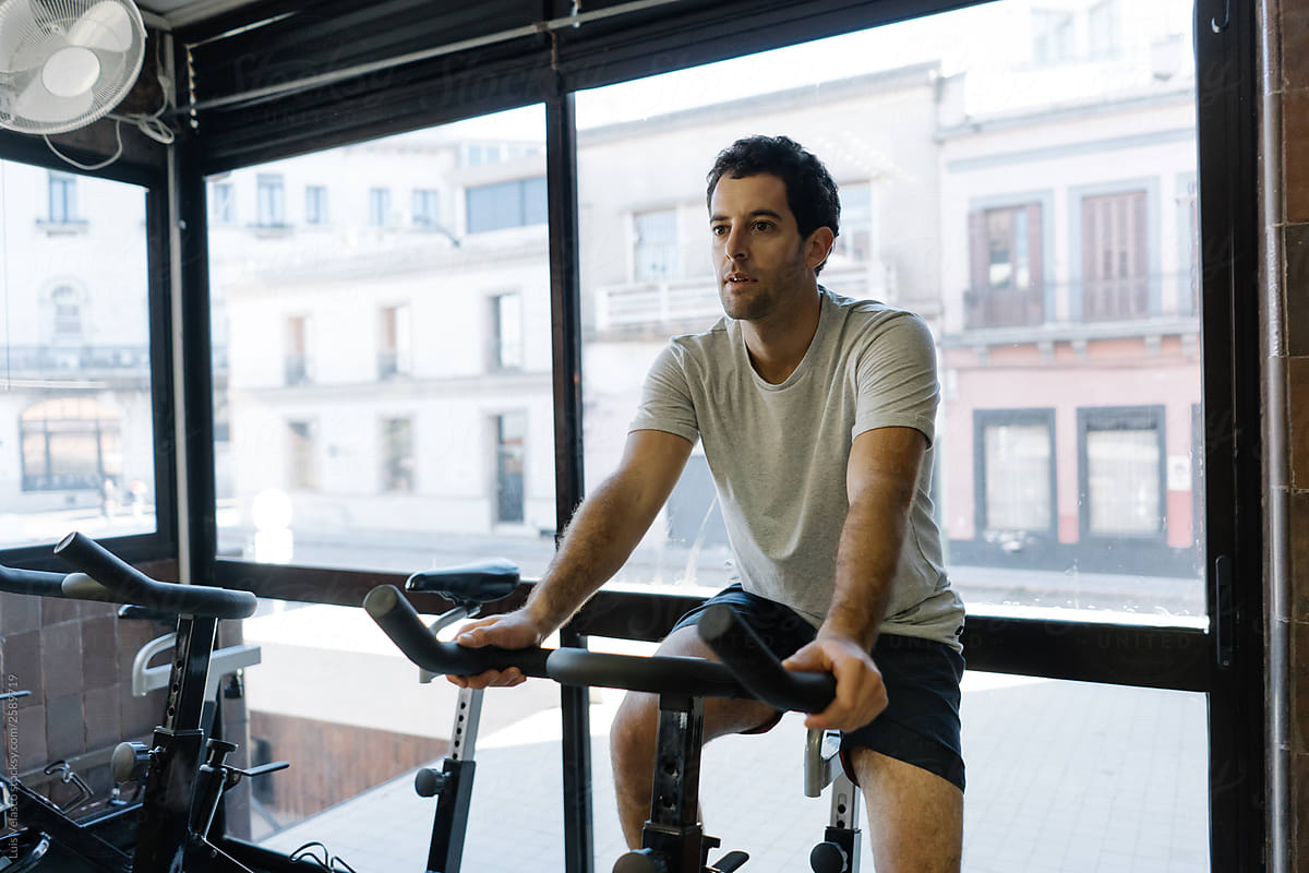 Brunette Man Using A Stationary Bicycle.