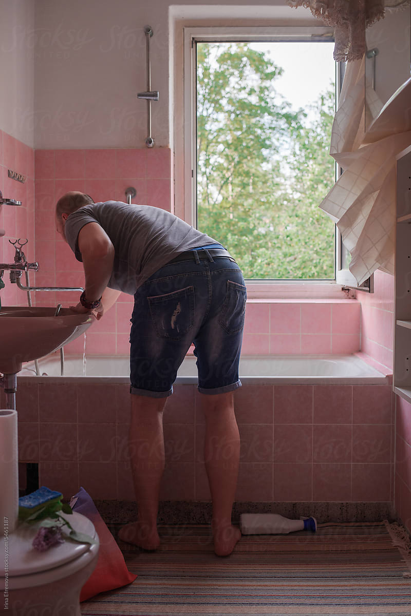 Man Cleans Pink-Tiled Bathroom for a Refreshing Bath