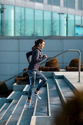 Woman Jogging In A Park Near The City by Stocksy Contributor MEM Studio  - Stocksy