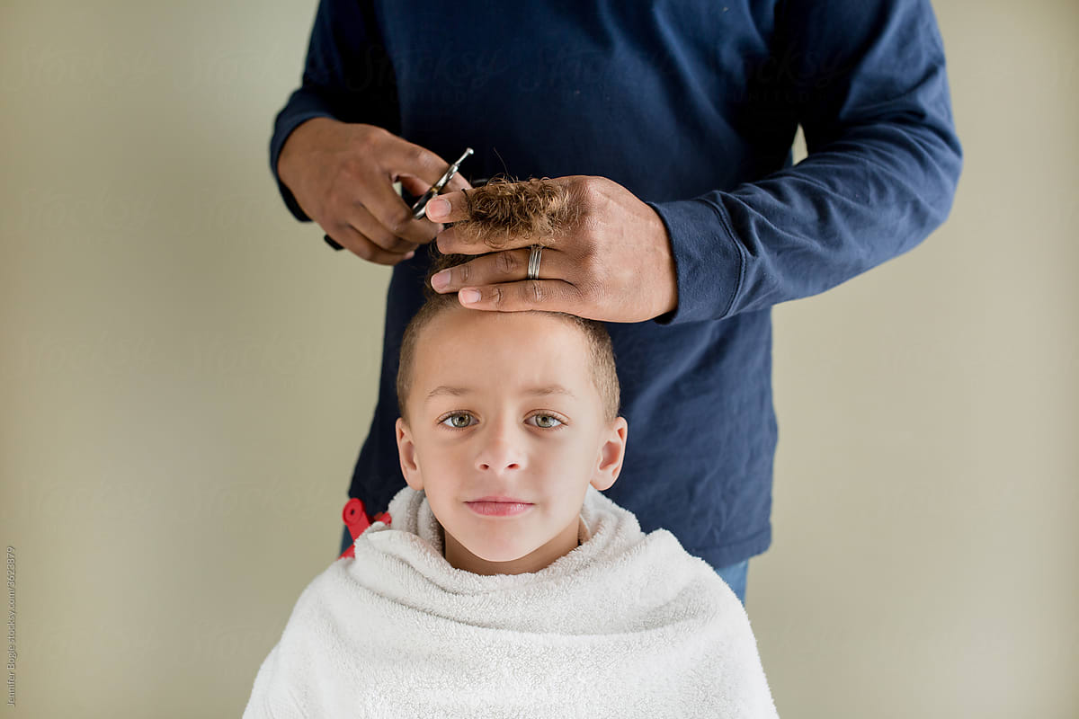 Boy wrapped in towel gets home haircut