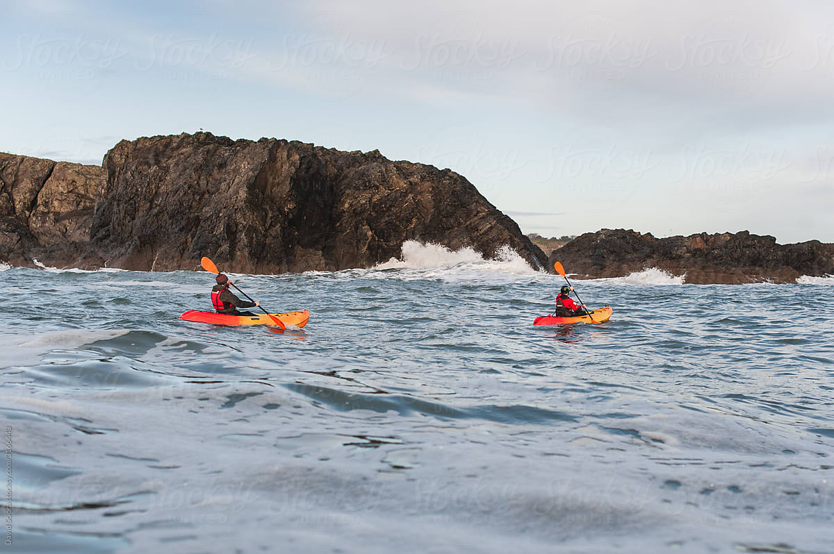 Two sea kayakers paddling on a rough sea.