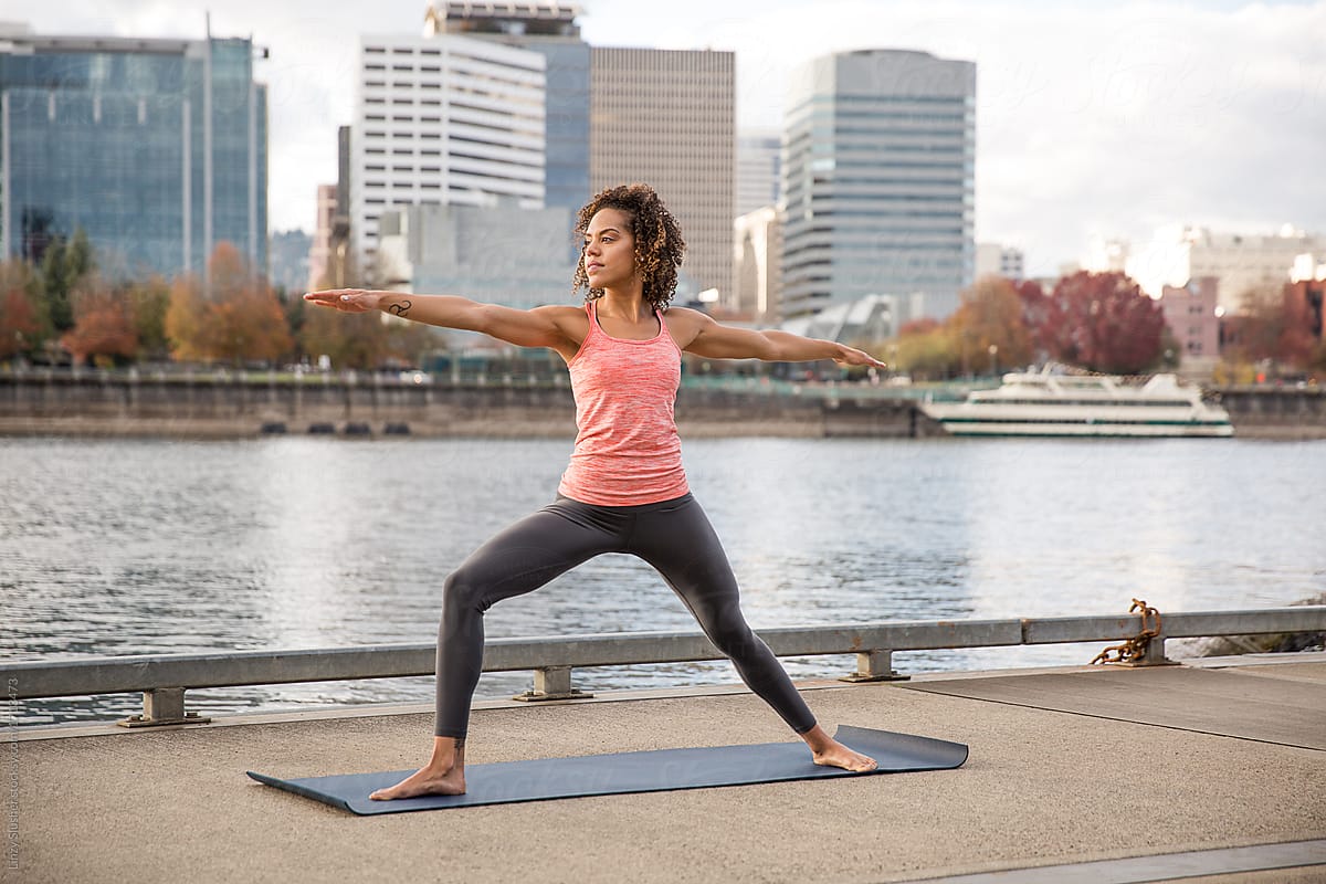 Mixed race female doing yoga on a waterfront