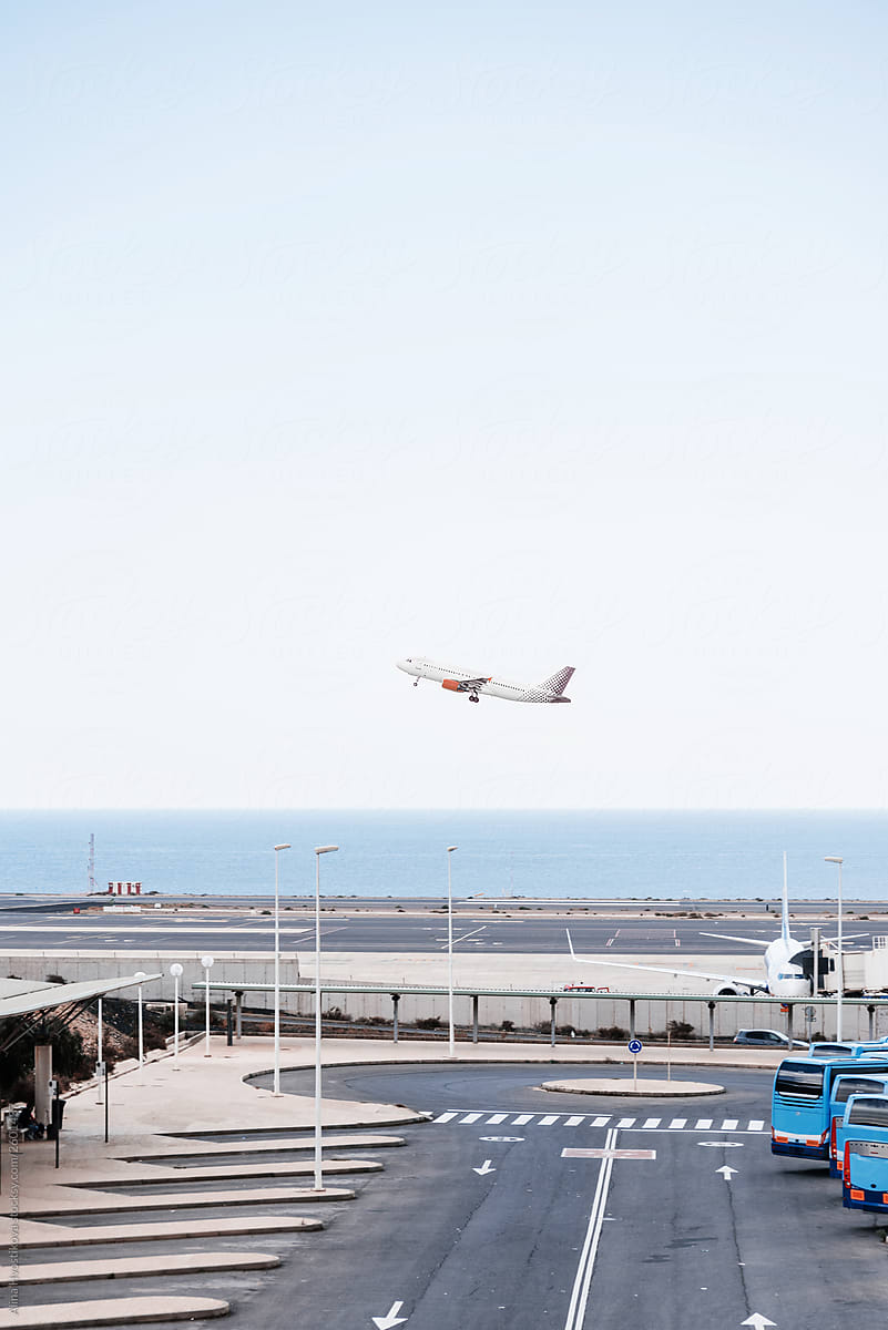 Plane flying  at airport near ocean coastline.