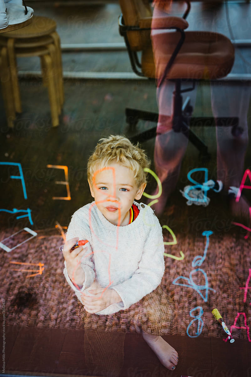 Little boy learning the alphabet with window markers