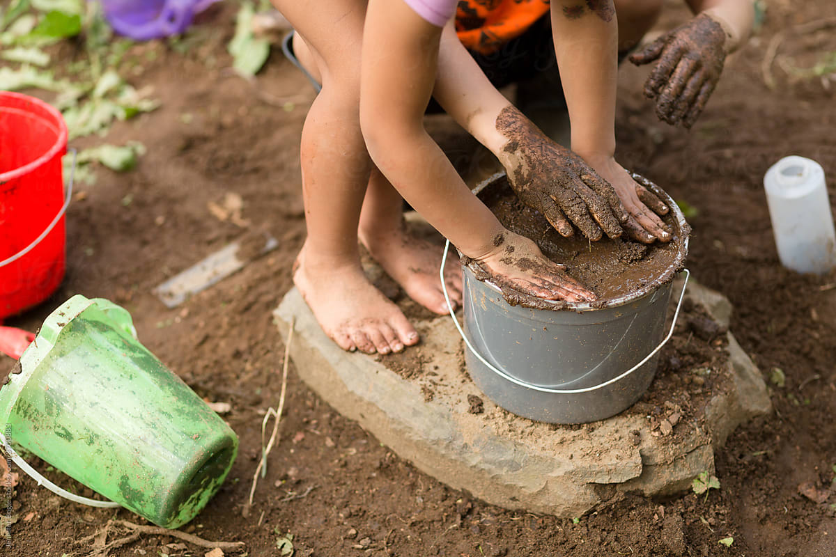Children with hands in mud
