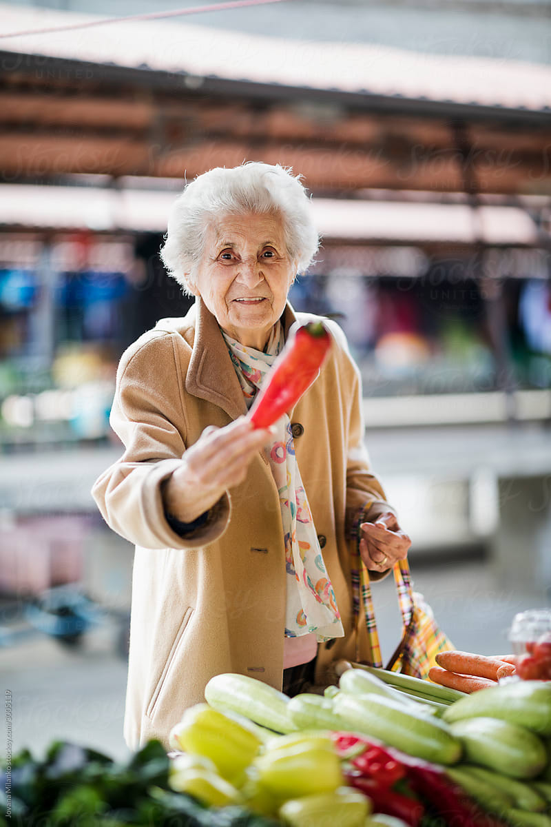 Senior woman at green market buying vegetables