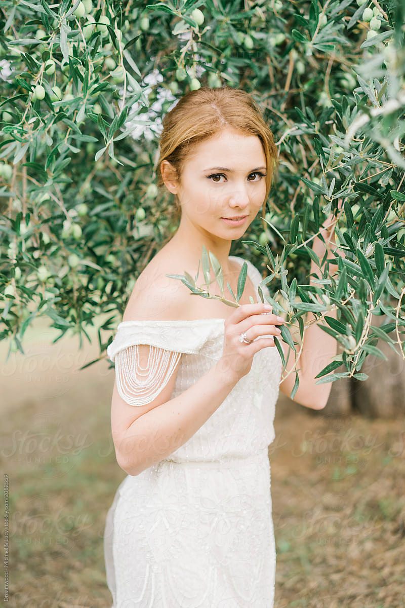 Wonderful woman in white dress under tree