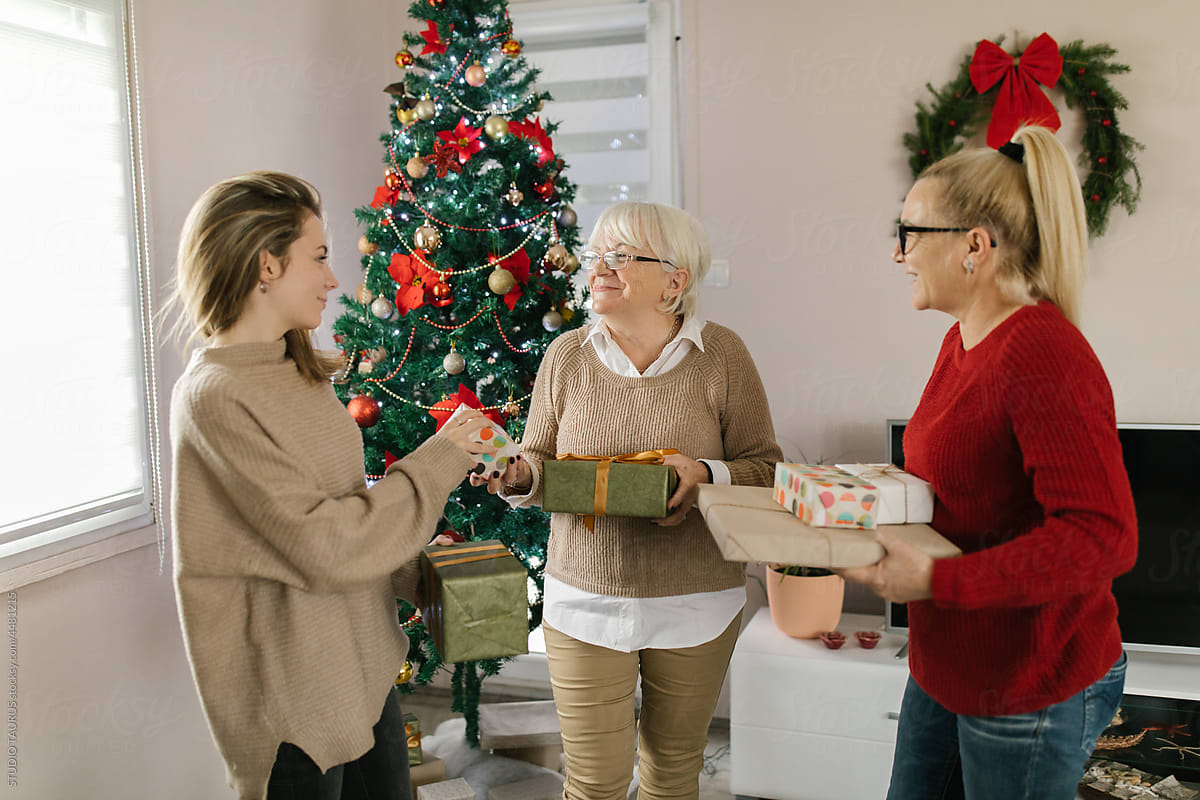 Happy women exchanging Christmas presents at home