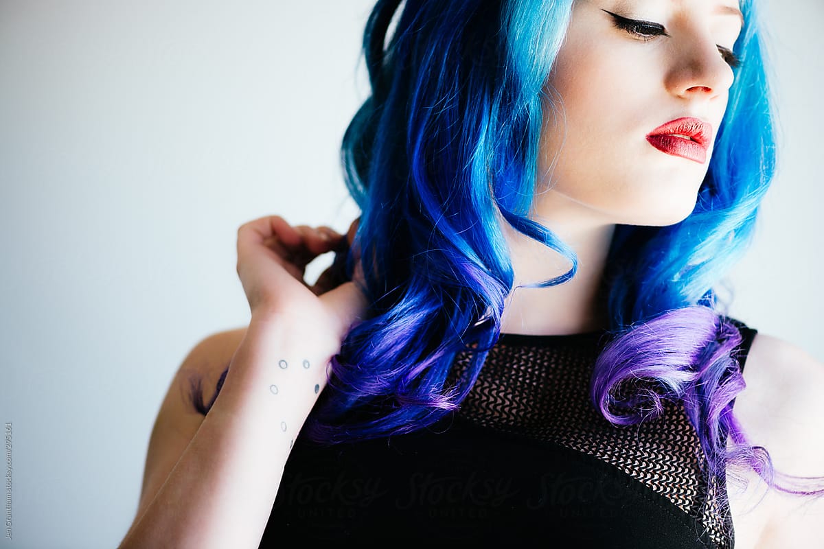 Tattooed model with blue hair in harsh light