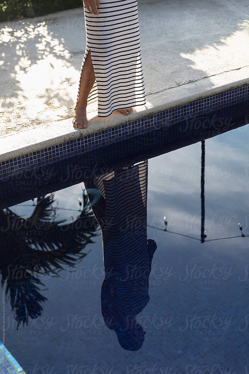 Beautiful woman Standing by Swimming Pool with reflection