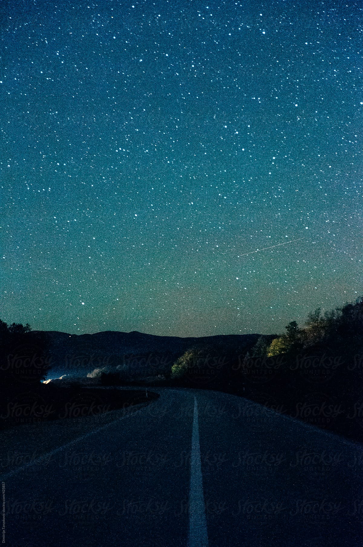 Stary sky above the road with car approaching in distance