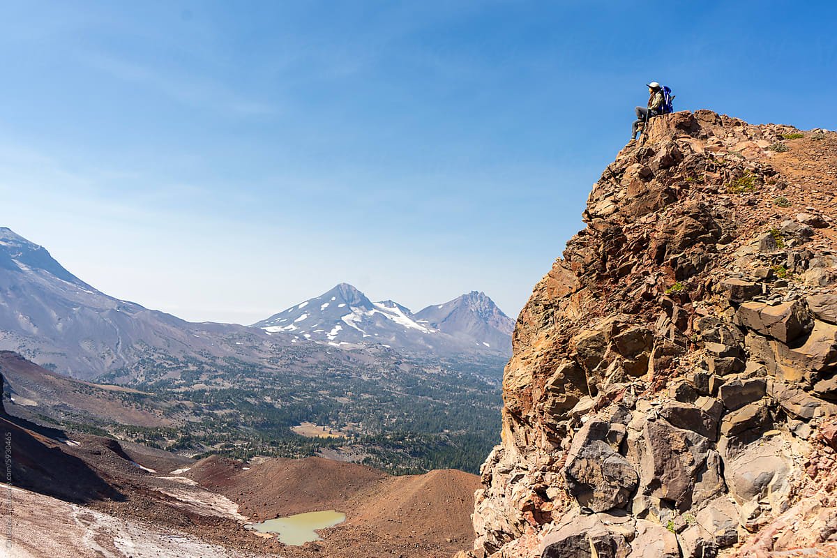 Hiker at rocky edge of cliff in Deschutes National Forest, Oregon