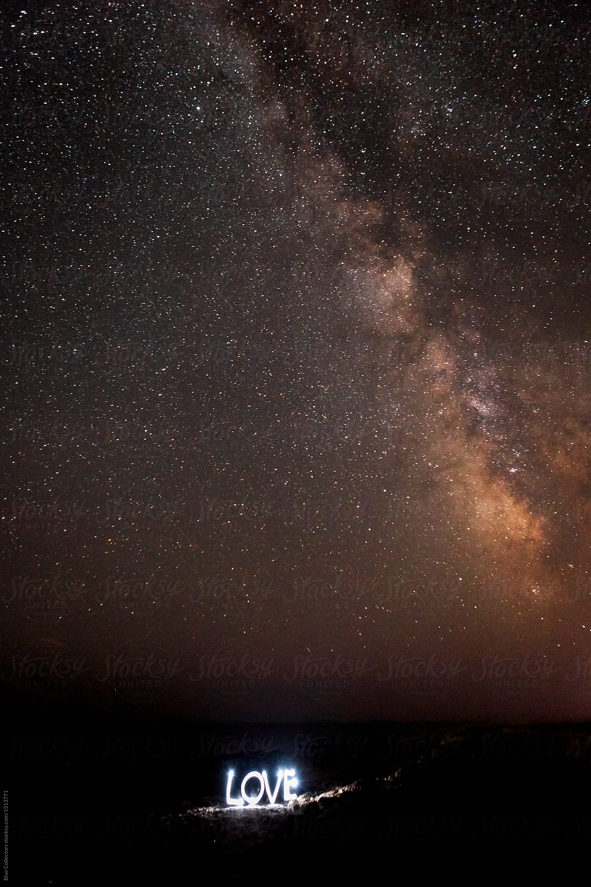 love word written with light under the Milky way in the coast