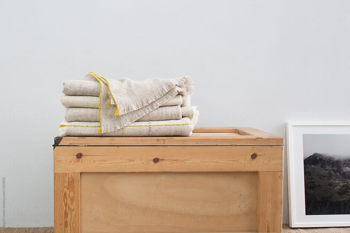 Linen blankets folded on wooden box