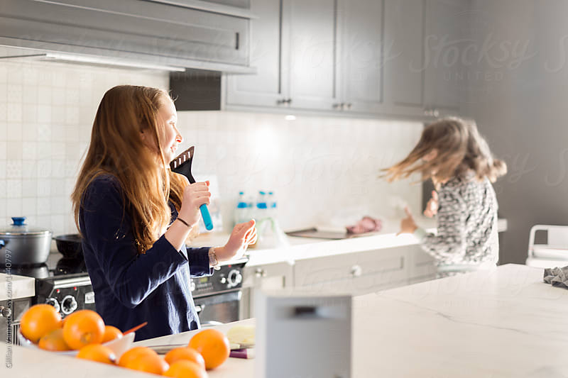 teens listening to music and dancing in the kitchen