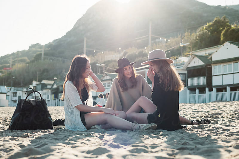 Young women relaxing at the beach at sunset