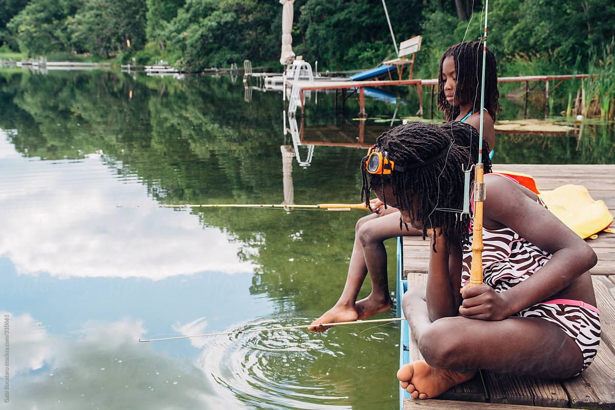 Three African American Girls In Swimming Suit Fishing By A Lake by Stocksy  Contributor Gabi Bucataru - Stocksy