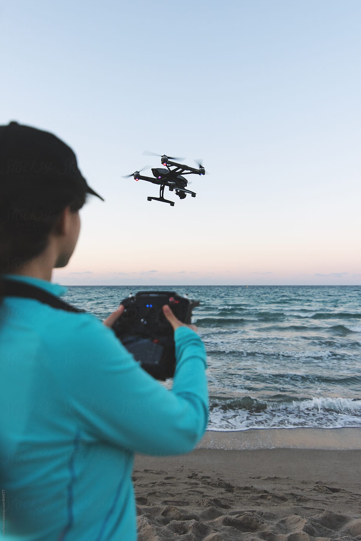 Active woman using a drone on the beach