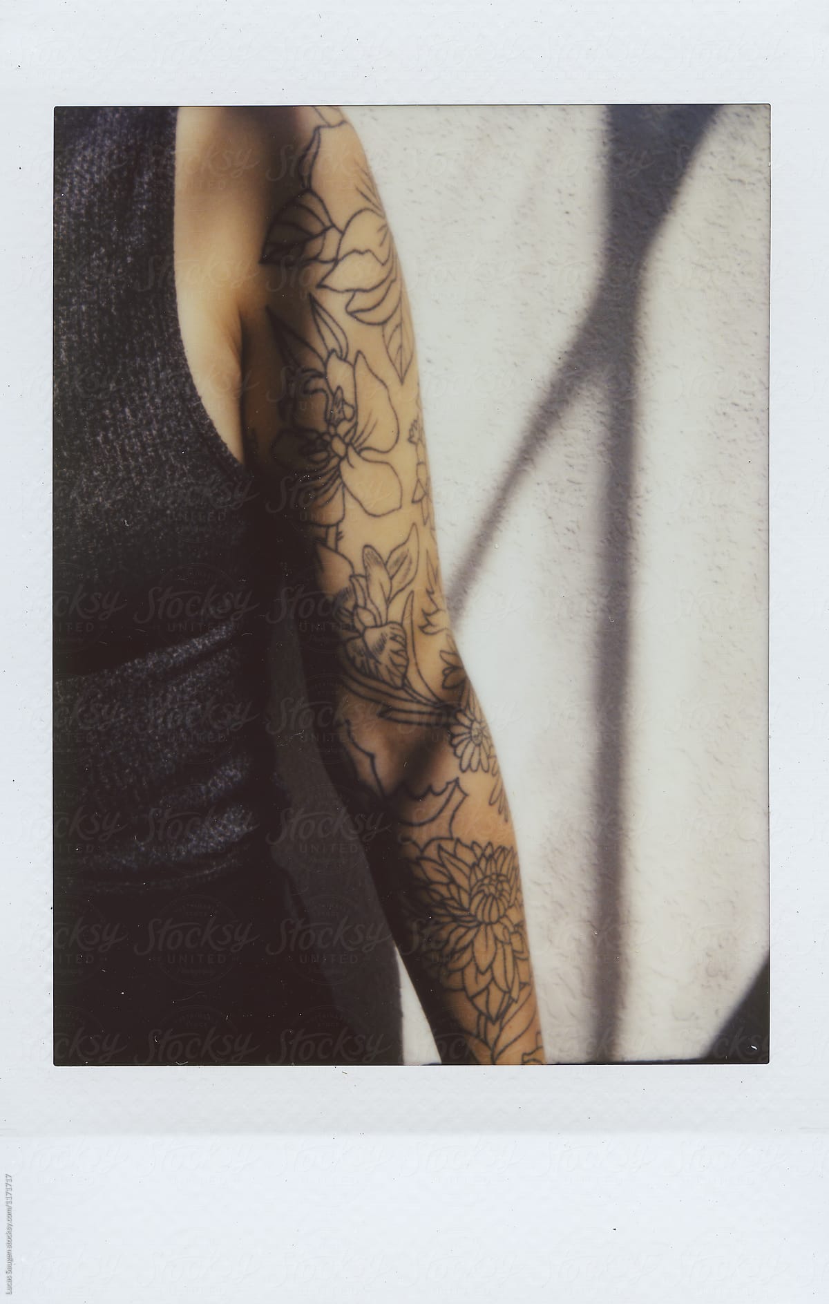 Polaroid of hand in tattoos