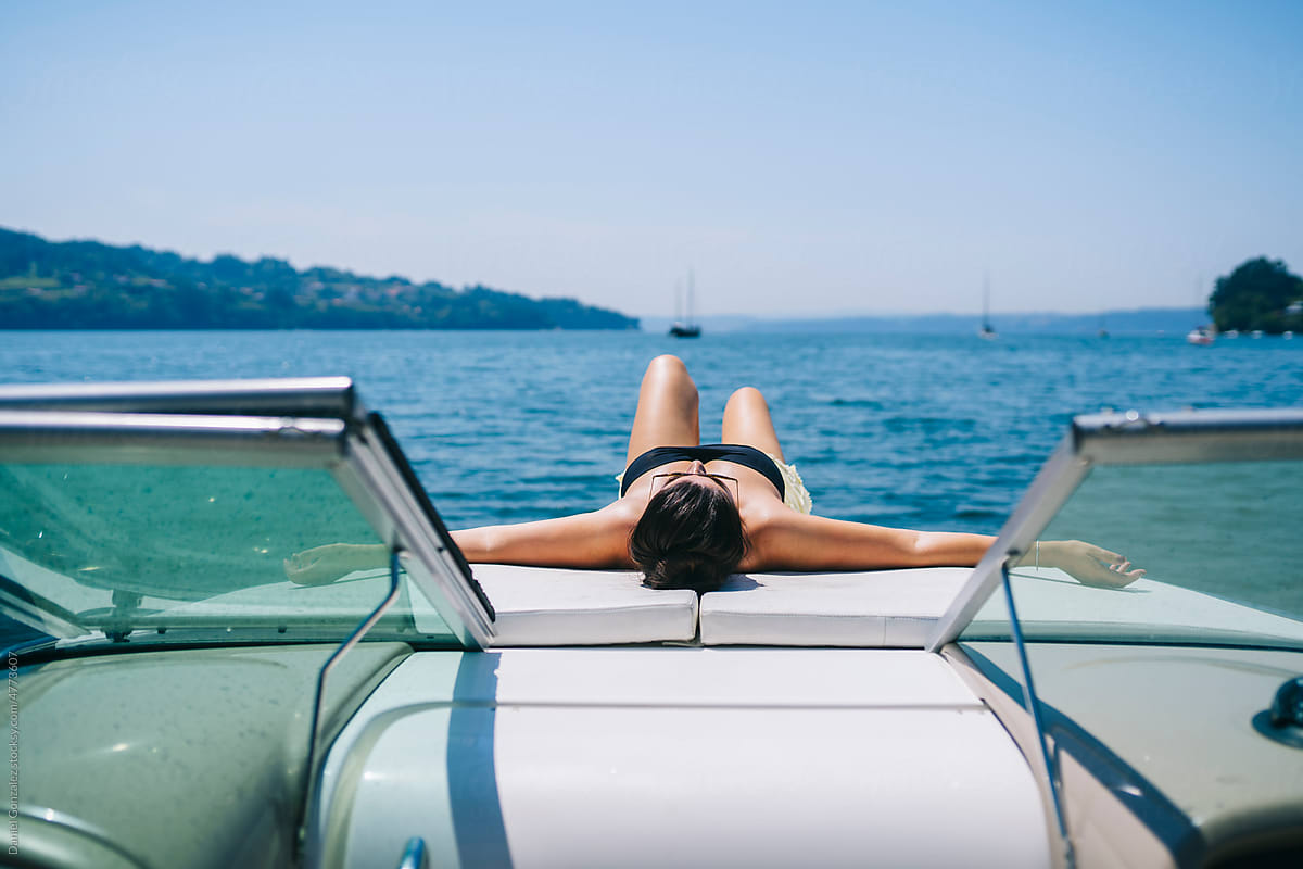 Anonymous woman sunbathing on boat floating in sea