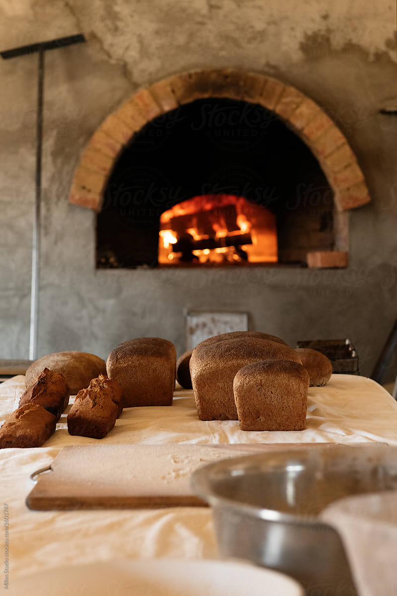 Bread loaves on table against stone oven