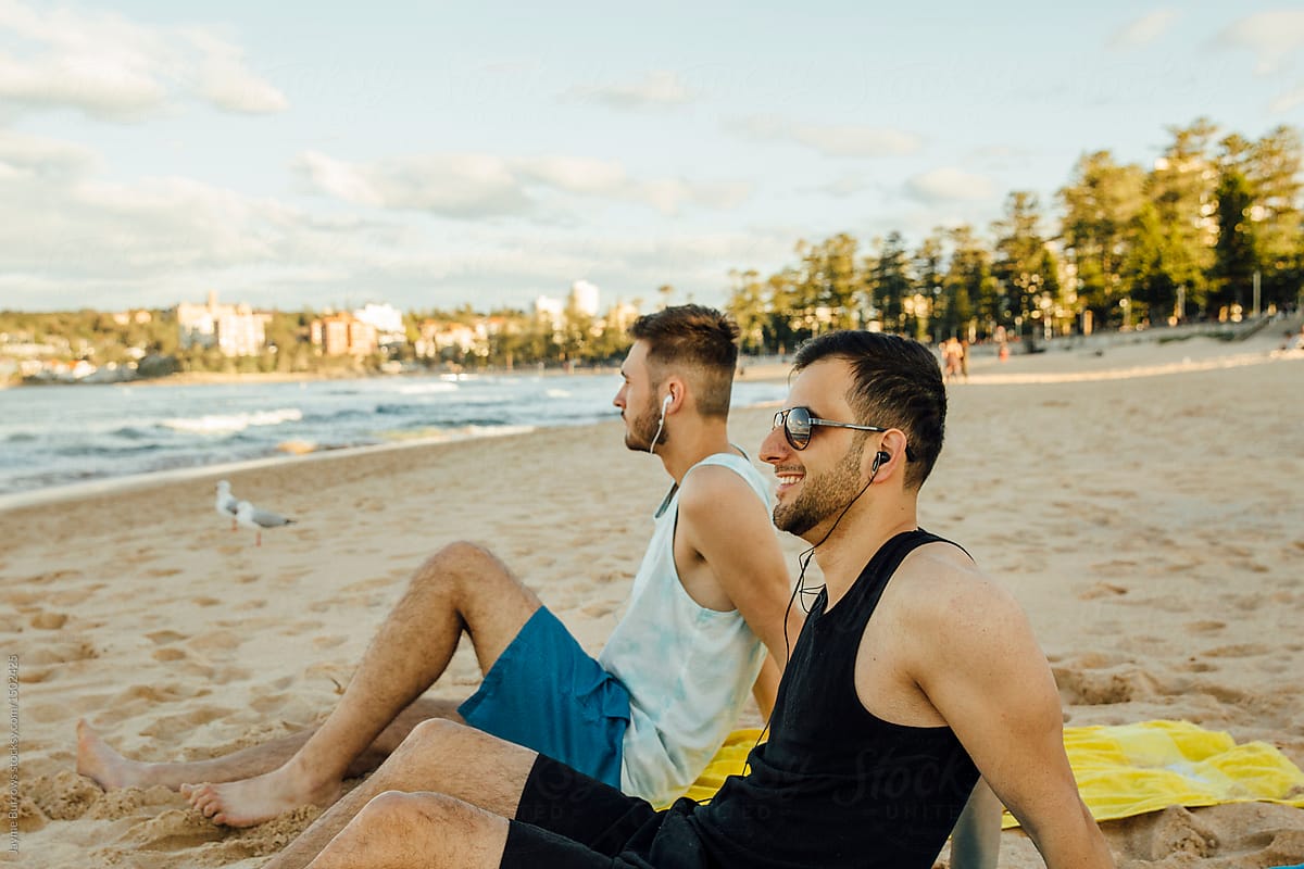 Male Friends Listening To Music On The Beach By Stocksy Contributor