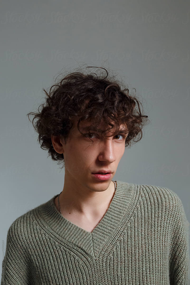 Young man with curly hair in studio