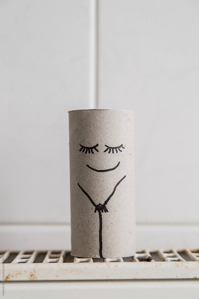 Empty toiletpaper roll with smiling slightly ashamed face drawn on it