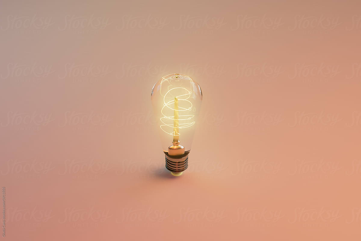Single Edison Bulb Glowing on Gradient Peach Background