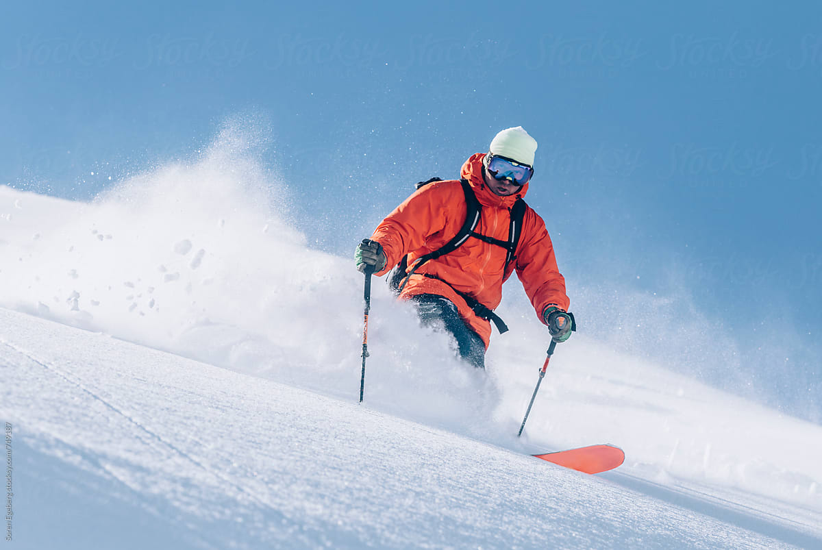 Skier Wearing Red Jacket Skiing Powder Snow In The Mountains by Soren ...
