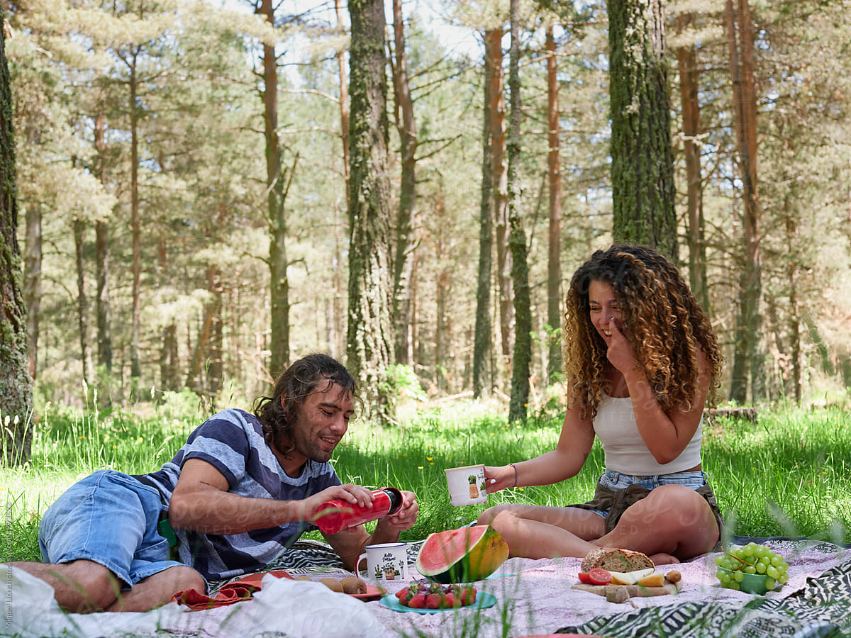 Couple having picnic in sunny woods