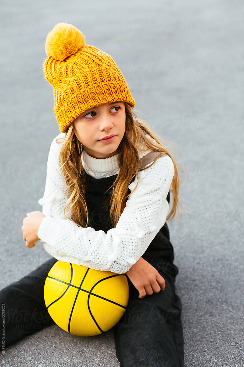 Sad girl sitting with yellow basketball