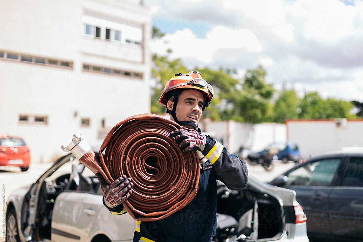 Firefighter carrying a fire hose