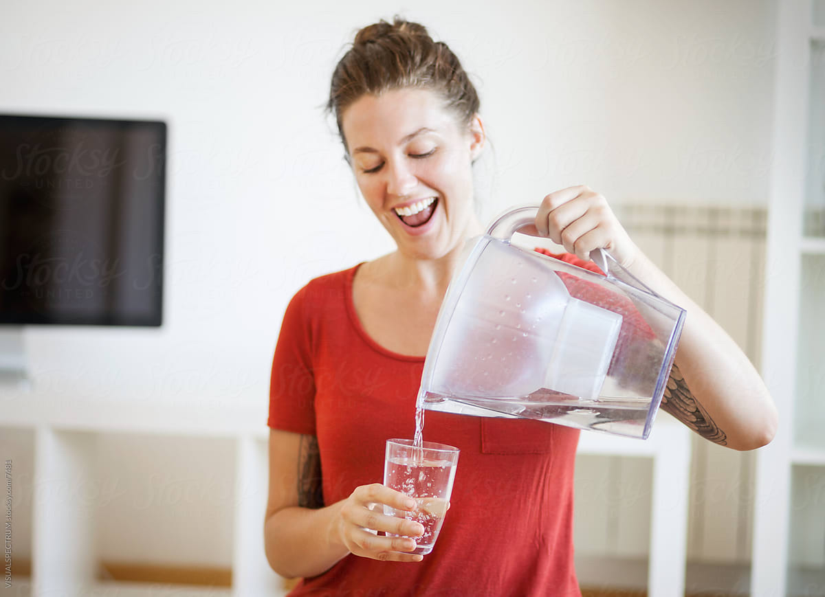 Young Woman Pouring Water Into a Glass