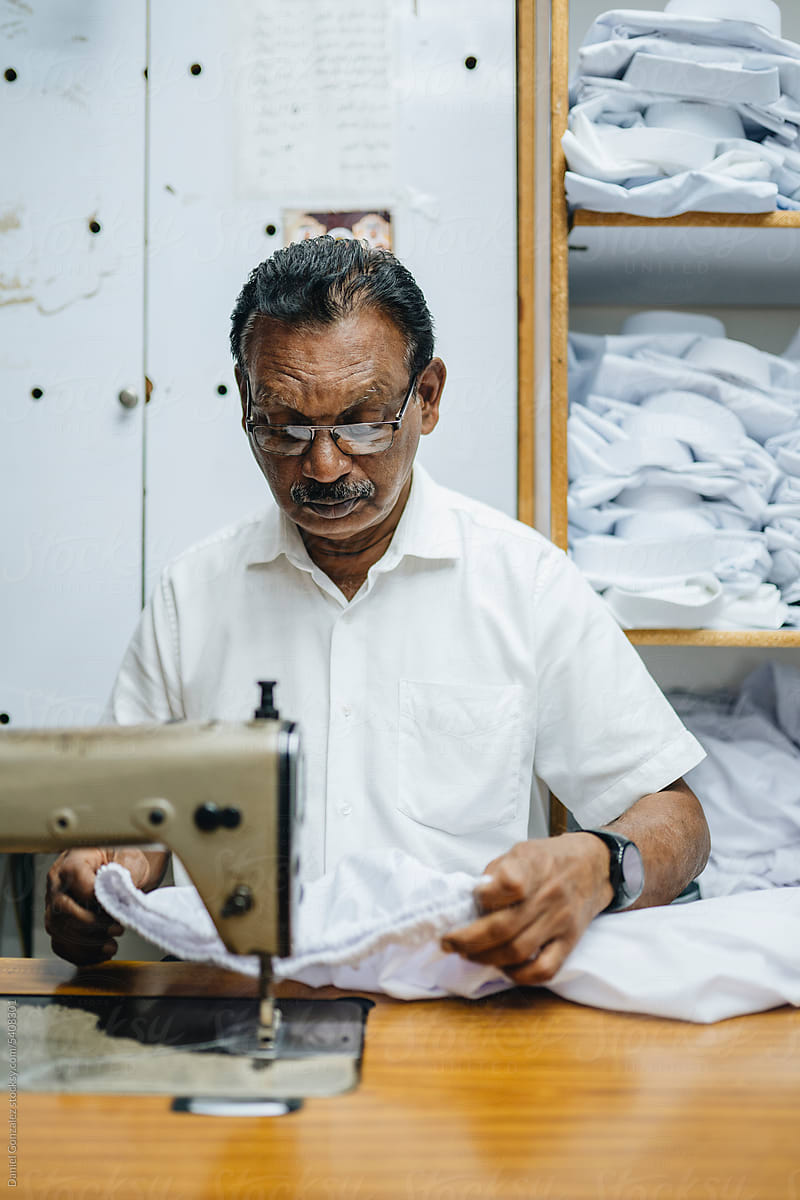 Calm Indian man working on sewing equipment in atelier