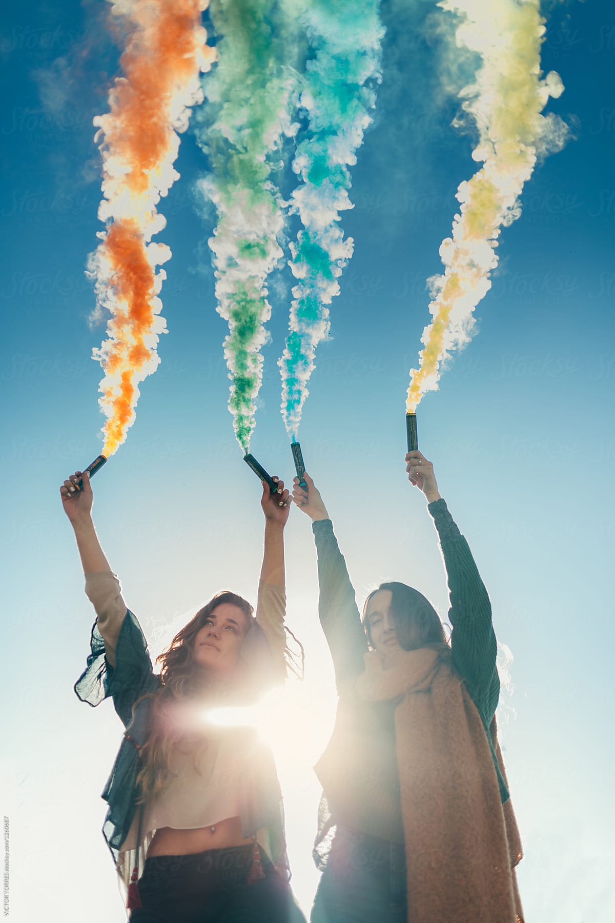 Two friends having fun outdoors with smoke bombs
