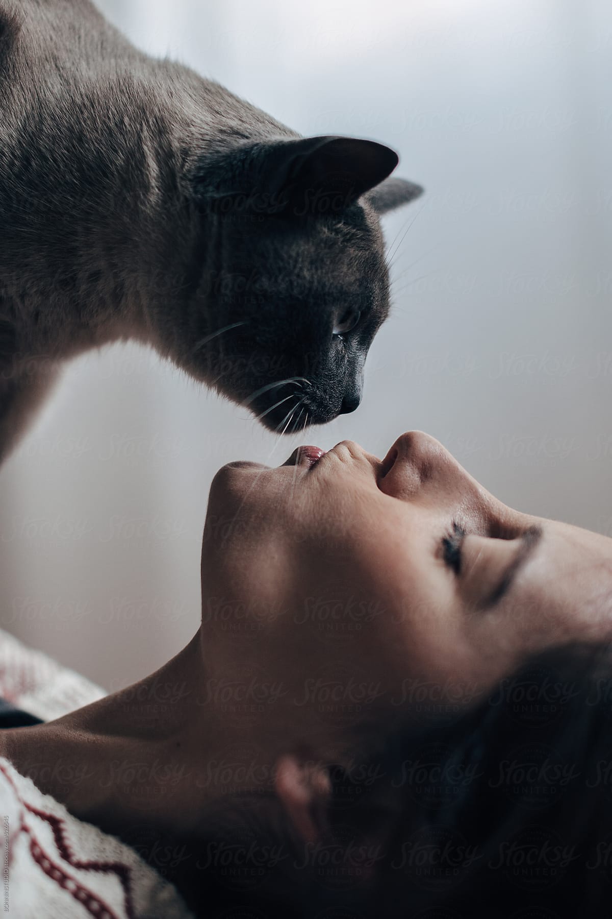 Closeup of a young woman kissing her beautiful cat.