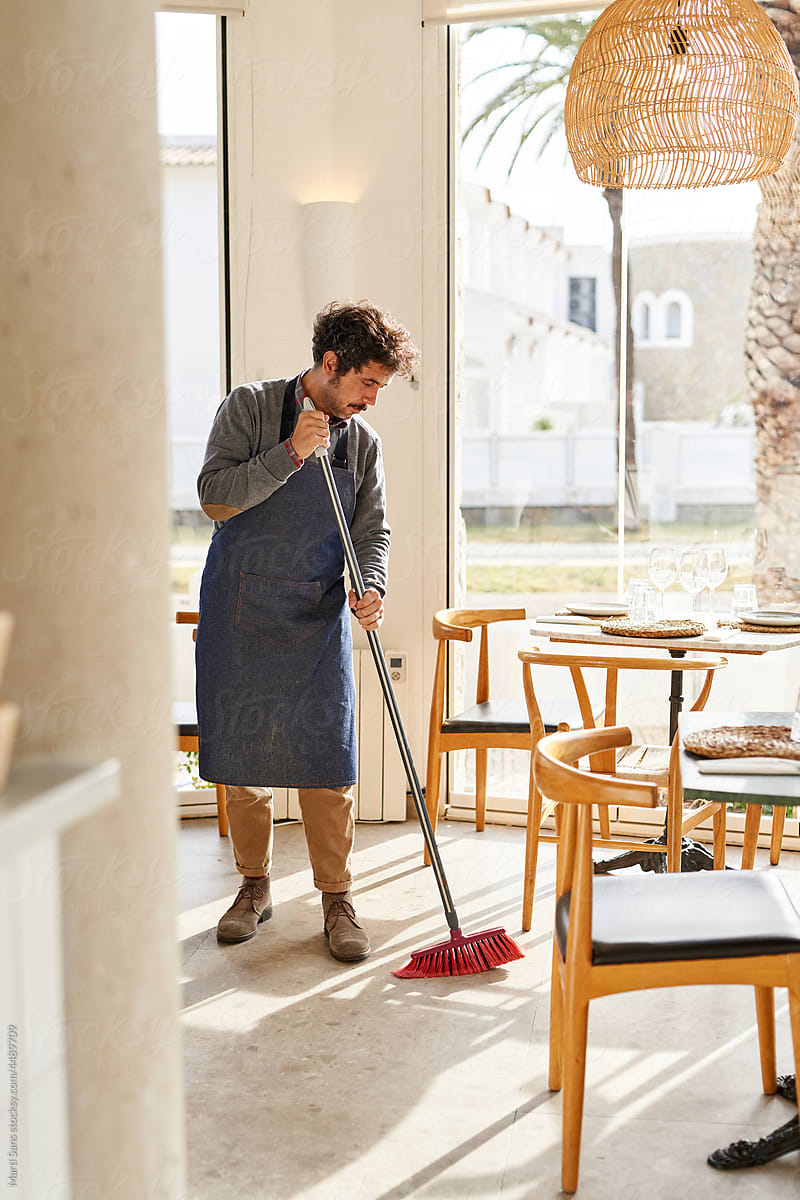 Man cleaning restaurant floor in morning