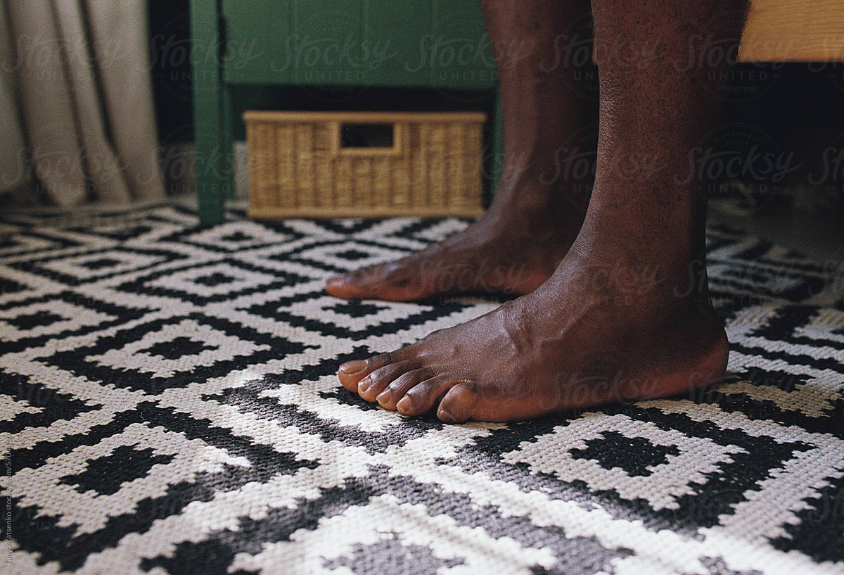 Man\'s barefoot by the bed