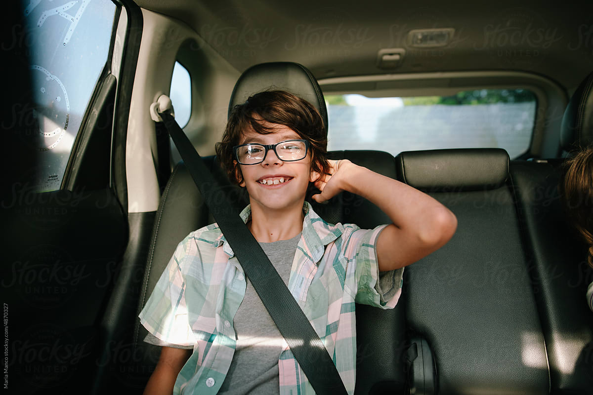 Child smiles sitting in backseat of car