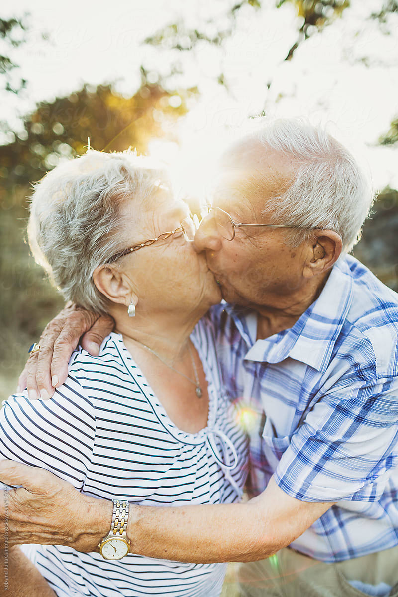 Elderly Couple Kissing In The Sunshine Stocksy United