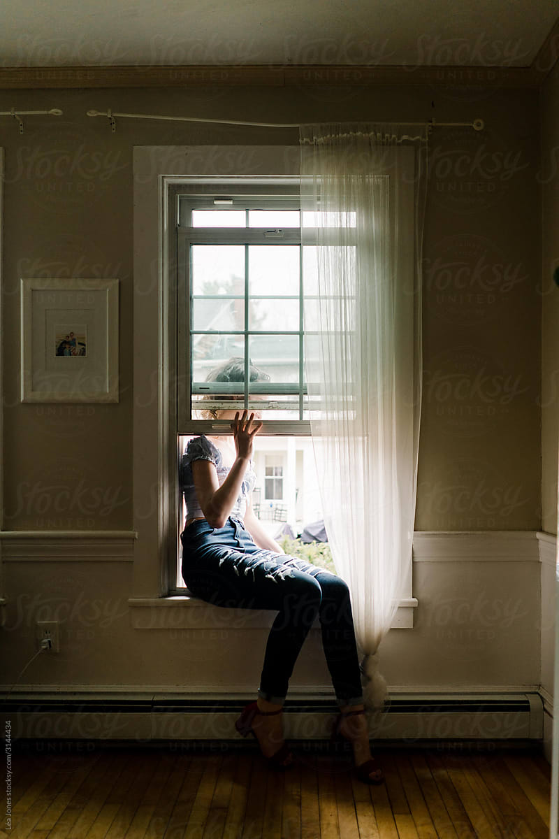 young woman escaping through window