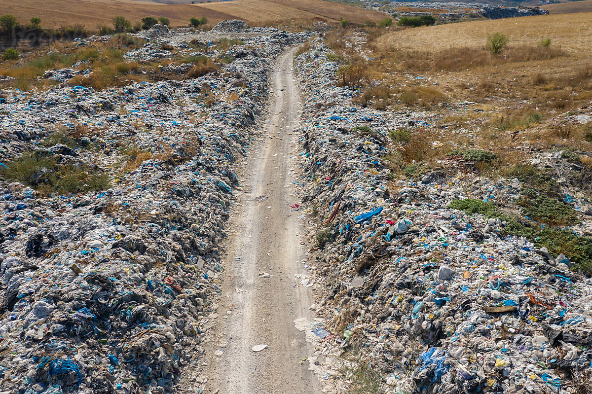 road to a garbage heap full on  plastic pollution