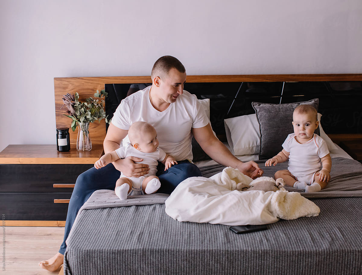 Father with baby twins in bedroom