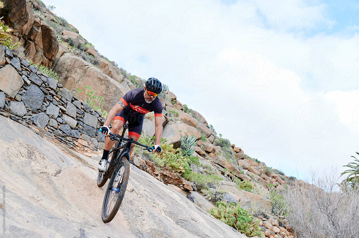 Man mountain biking down a rocky slope